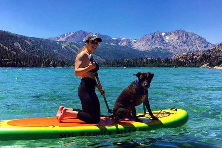 a woman and her dog on a SUP rental